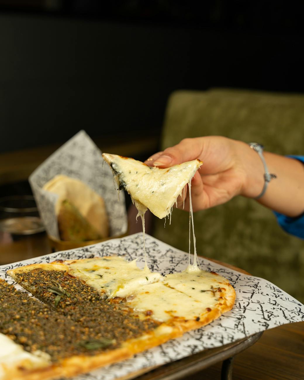 woman hand holding slice of pide